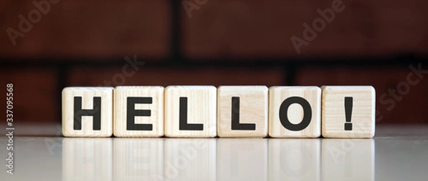 Fototapeta HELLO - HI concept on on a dark brick background. Wooden cubes with text