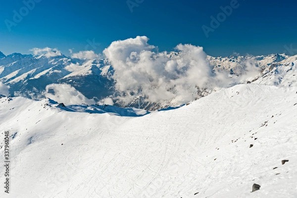 Fototapeta Panoramic view down snow covered valley in alpine mountain range