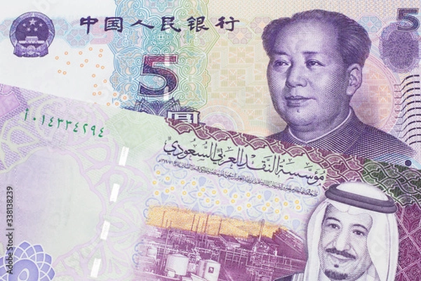 Fototapeta A close up image of a five riyal note from Saudi Arabia along with a five yuan bank note from the People's Republic of China