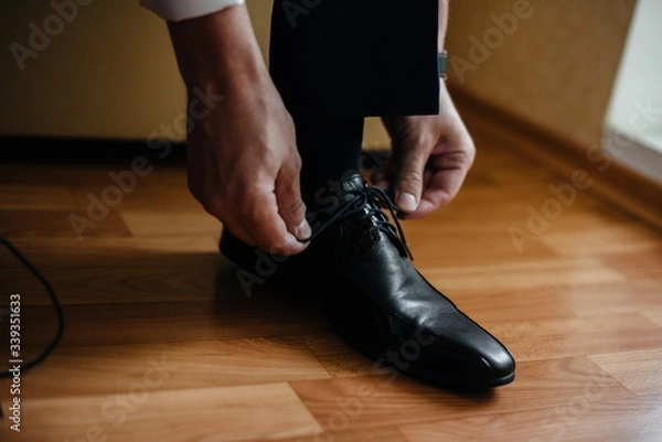 Fototapeta A stylish man wears classic shoes close-up. Fashion