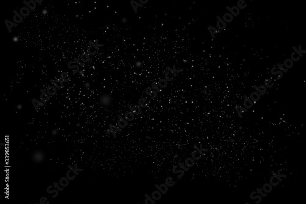 Fototapeta Dust particle on black abstract background. White dust element bokeh pattern flying in a dark