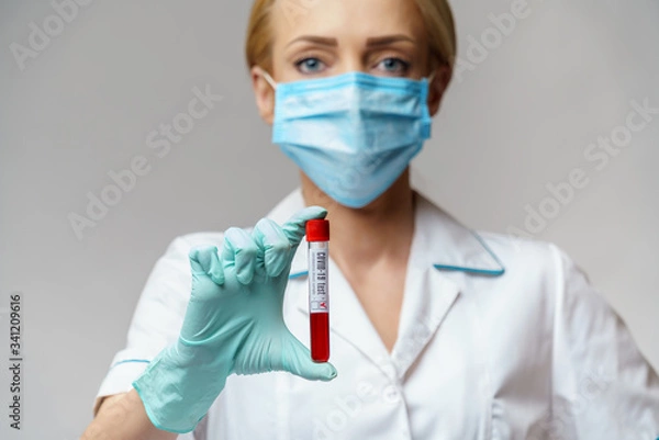 Fototapeta medical doctor nurse woman wearing protective mask and gloves - holding virus blood test