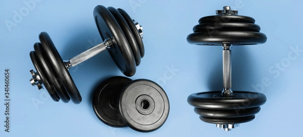 Fototapeta Professional dumbbell and weight plates over blue background. Gym equipment. Fitness concept.