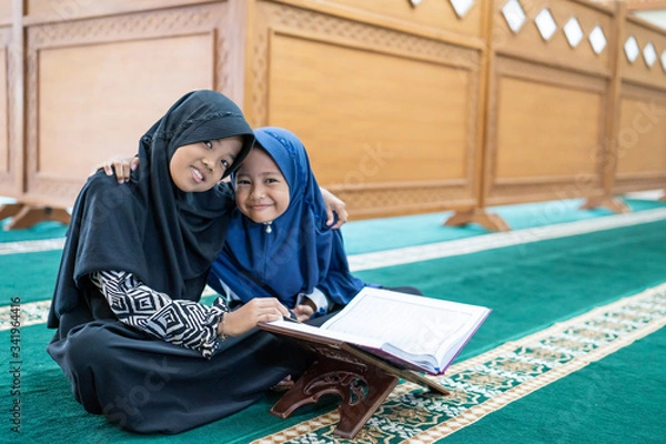 Fototapeta happy muslim asian kid smiling during reading quran together at the mosque