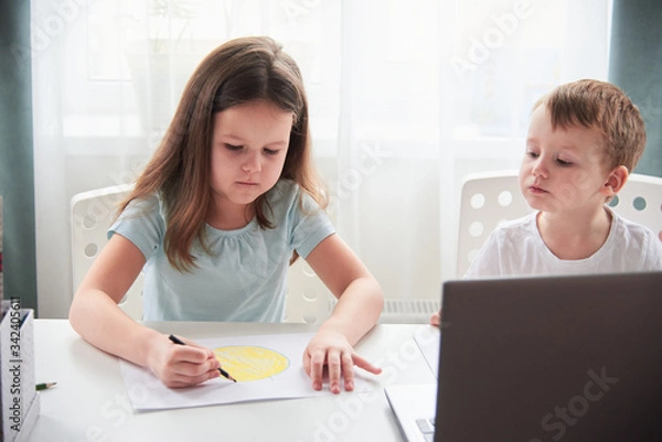 Fototapeta Smiling boy and girl with a laptop. Online lessons