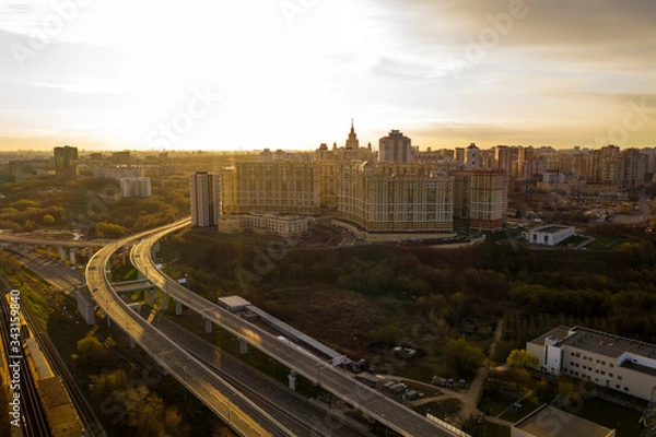 Fototapeta panoramic view with skyscrapers and highways of a big city filmed from a drone