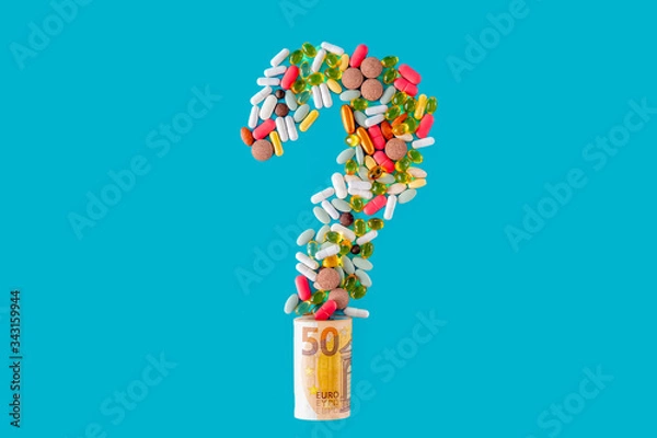 Fototapeta Multicolor tablets and capsules in the form of a question mark emerging from twisted euro banknotes on a blue background.Healthcare spending concept, selective focus.