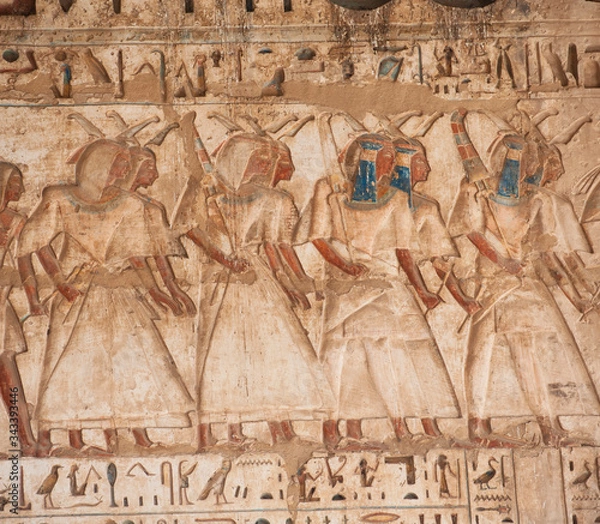 Fototapeta Hieroglyphic carving painting on an ancient egyptian temple wall