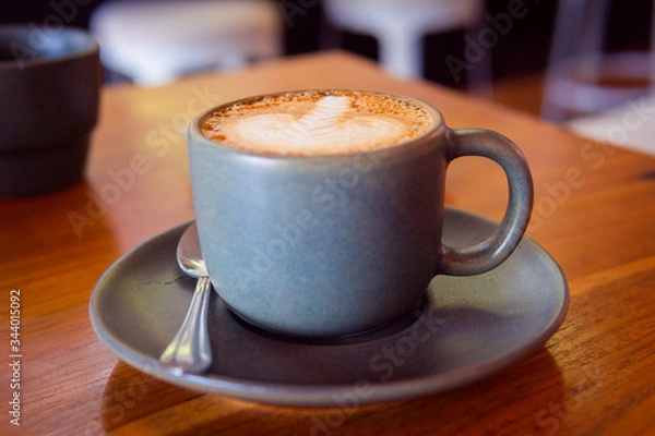 Fototapeta Cup of coffee on a wooden table. Hot cappuccino