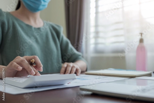 Fototapeta Coronavirus. Business woman working from home wearing protective mask. Business woman in quarantine for coronavirus wearing protective mask. Working from home.