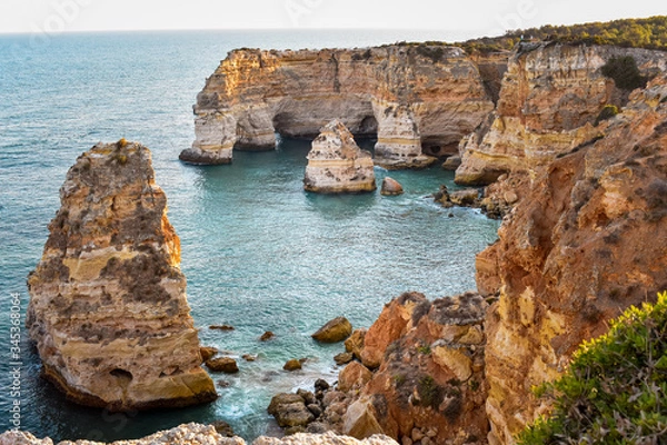 Fototapeta View from above from the viewpoint of the natural arches. . Orange cliffs and turquoise waters. Concept of tourism and travel. Algarve, Portugal