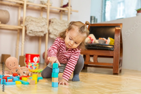 Fototapeta Adorable little girl playing on the floor