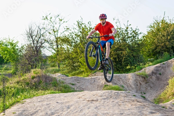 Fototapeta Extreme cycling concept, cyclist jumping on a mountain bike.