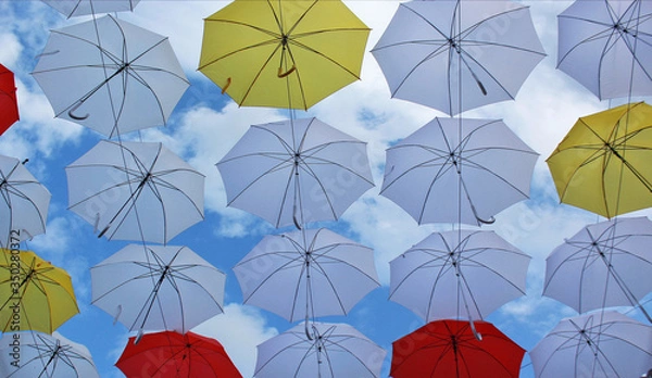 Fototapeta Multicolored street decoration umbrellas on a summer sunny day