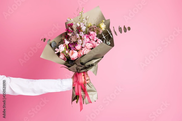 Fototapeta Photo of cropped man arm hold big bright decorated bunch giving girlfriend valentine day romance gift present bouquet composition isolated pink color background