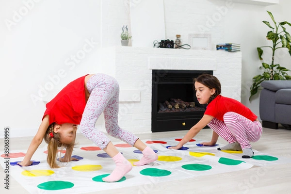 Fototapeta two little girls Having Fun Playing Game On Floor At Home. Siblings Friendship