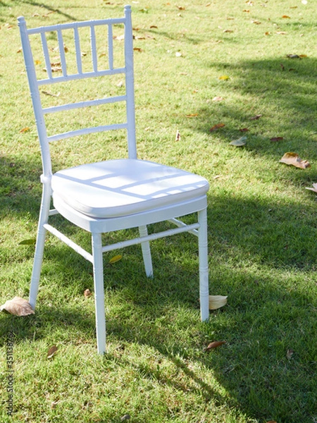 Fototapeta White wooden chair in the lawn.