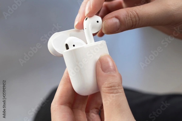 Obraz Wireless headphones in a hand. White wireless headphones