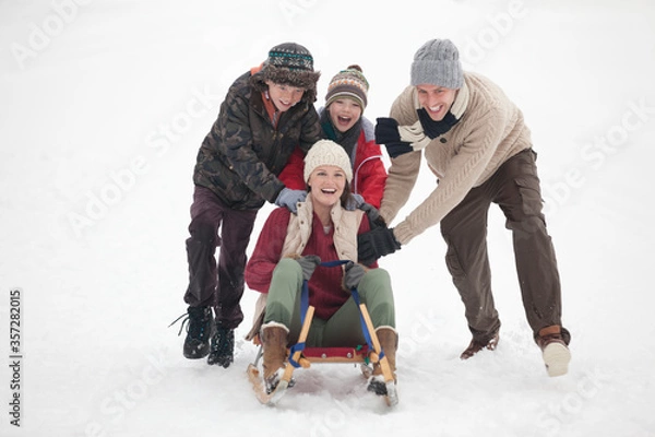 Fototapeta Happy family sledding in snow