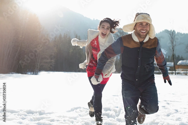 Fototapeta Couple running in snow