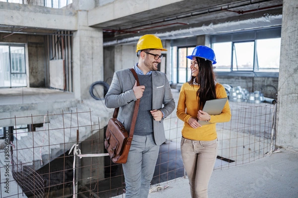 Obraz Two architects walking in building and talking job.