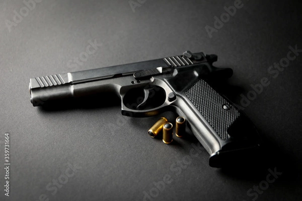 Fototapeta Pistol and traumatic bullets on black background. Self defense weapon