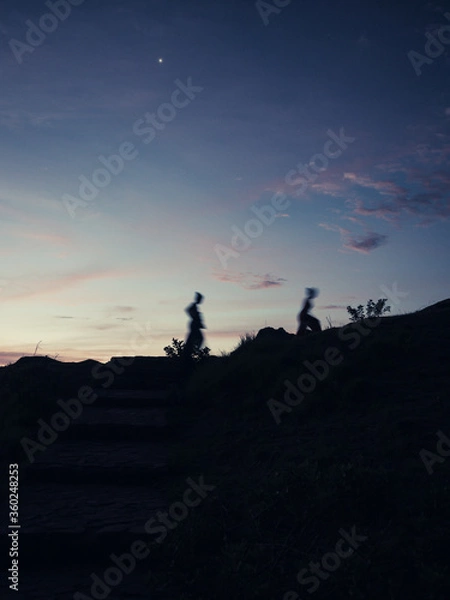 Fototapeta intention motion blur people. Silhouette people walking on hill in sunset. Trekking and outdoors concepts. 