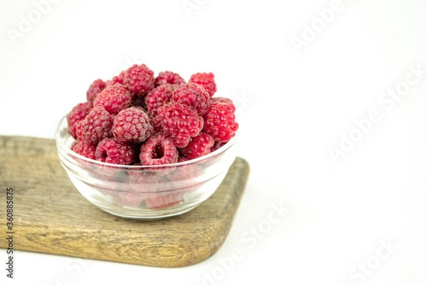 Fototapeta fresh ripe raspberry in a glass transparent bowl on white background