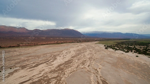 Fototapeta Natural textures. Aerial view of the arid desert, sand, dunes and mountains under a cloudy sky. 