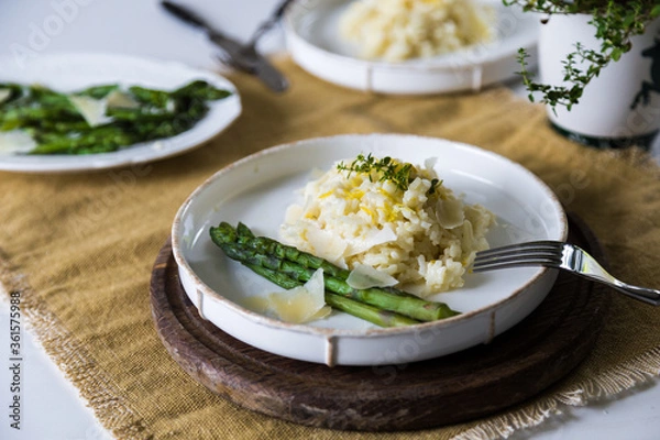 Fototapeta Creamy lemon risotto with parmesan and asparagus on white plate.