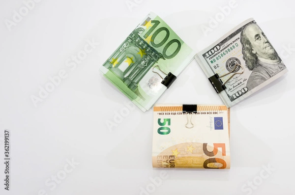 Fototapeta Euro and dollars with a clip on a white background. Financial concept. Savings concept. Copy of space.