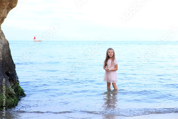 Fototapeta Cute girl stands on the seashore in summer