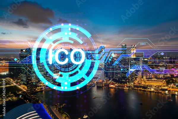 Fototapeta Hologram of glowing ICO icon, sunset panoramic city view of Singapore, startup incubator of cryptocurrency projects in Asia. The concept of affordable opportunities in new era. Double exposure.