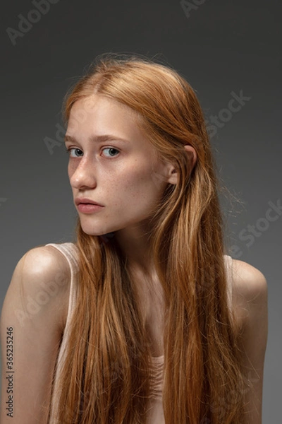 Fototapeta New look. Fashion portrait of beautiful redhead woman isolated on grey studio background. Concept of beauty, skin care, fashion and style. Artwork, modern and trendy portrait. Attractive model.