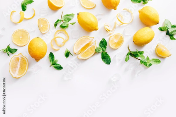 Fototapeta Fresh cut lemon and mint leaves on white background. Top view