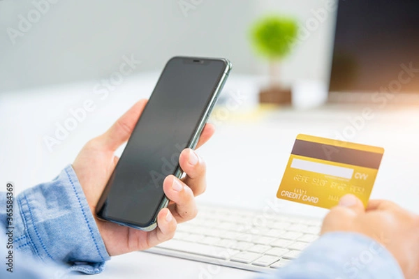 Fototapeta Hands holding credit card and using laptop. working at home. Online shopping, e-commerce, internet banking, spending money, working from home concept