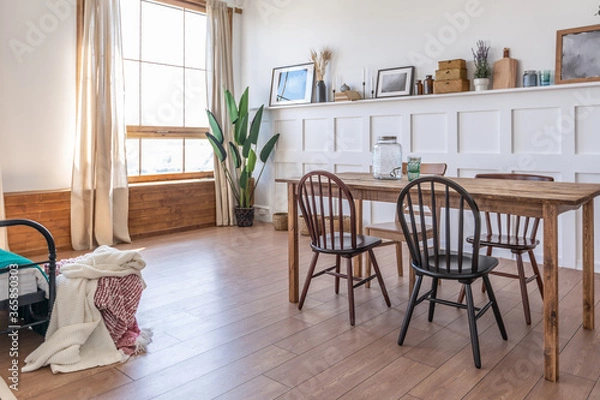 Fototapeta Vintage studio apartment interior in light colors in old style. huge room with large windows with a living room area and a bedroom area. direct sunlight inside.