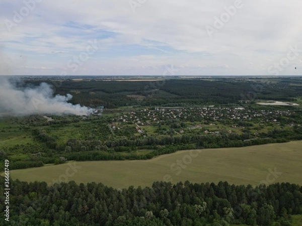 Fototapeta Fire and white smoke with rural summer landscape