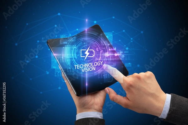 Fototapeta Businessman holding a foldable smartphone with TECHNICAL inscription, new technology concept TECHNOLOGY VISION