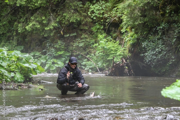 Fototapeta A fisherman walking for wild river and a breathtaking scene in the forest with colourful reflections on the river. Fishing day hunting for a trout. Finding solitude in the wilderness.