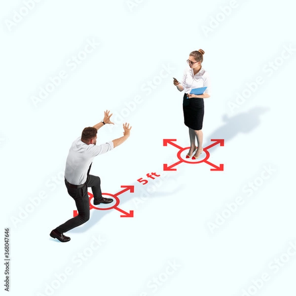 Fototapeta Studio shot of people demonstrating social distancing with arrows indicating the separation. Office workers during coronavirus outbreak with new rules for safety and healthcare. High angle view