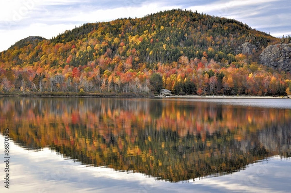 Fototapeta Late autumn afternoon in New Hampshire’s Franconia Notch State Park. Colorful fall foliage reflecting on calm surface of Echo Lake. Artists Bluff, with open ledges, at far top right.