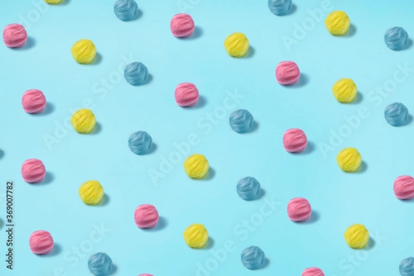 Fototapeta Colorful Wolen Balls on a bright blue background. Summer colors inspired art photography. Cotton Candy overload in yellow, pink, and blue colors.