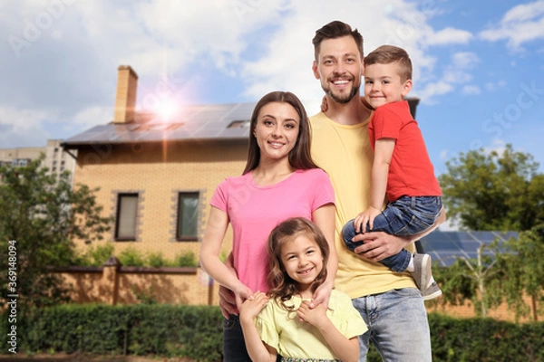 Fototapeta Happy family near their house with solar panels. Alternative energy source