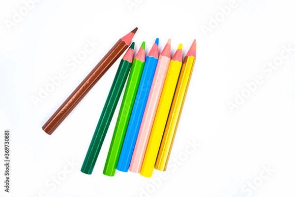 Fototapeta Seven different colored wood pencil crayons scattered on a white background