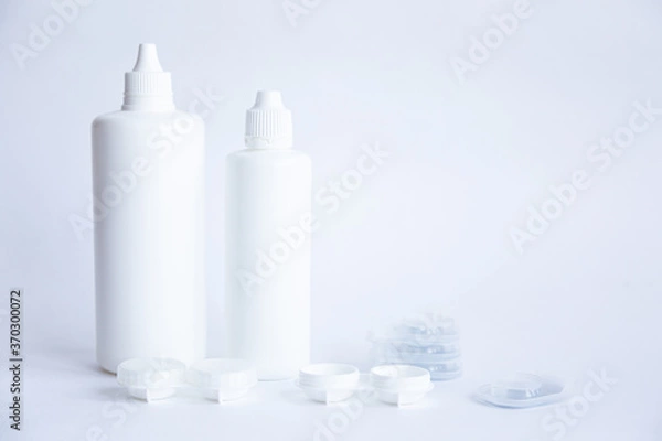 Fototapeta Contact lenses lens care products in white bottles on white background lens containers