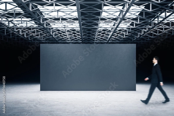 Fototapeta Businessman walking in showroom with exhibition stand