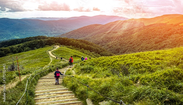 Fototapeta Child hiking in the mountains at sunset. BIeszczady Poland.