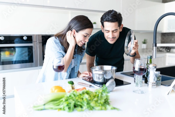 Fototapeta Couple Preparing Food In Kitchen At Home