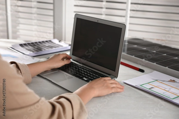 Fototapeta Woman working on house project with solar panels at table in office, closeup